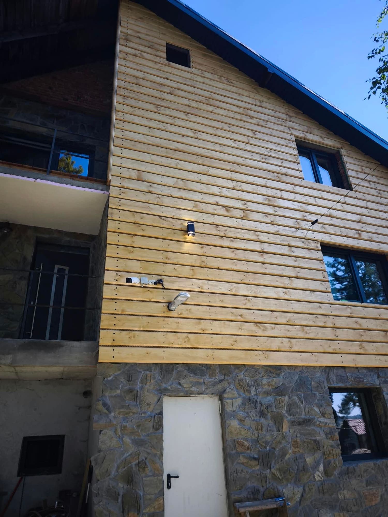 Holzfassade der Apartments auf steinernem Sockel